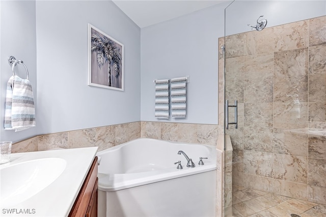 bathroom featuring vanity and independent shower and bath