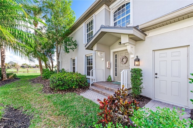 view of exterior entry featuring a yard