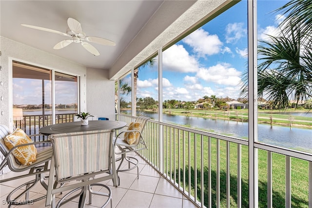 sunroom / solarium with a water view and ceiling fan