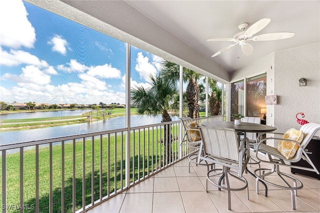 sunroom / solarium featuring ceiling fan and a water view