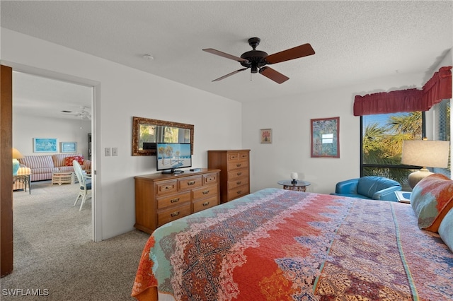 bedroom featuring ceiling fan, light colored carpet, and a textured ceiling