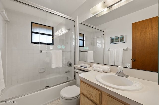 full bathroom featuring vanity, bath / shower combo with glass door, and toilet