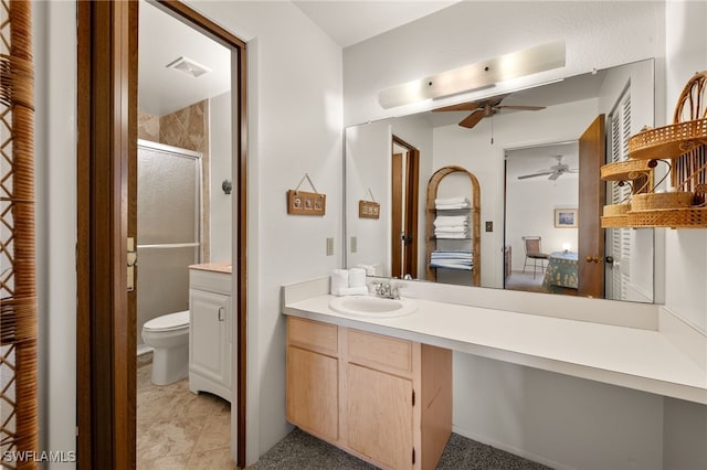 bathroom featuring vanity, ceiling fan, a shower with shower door, and toilet