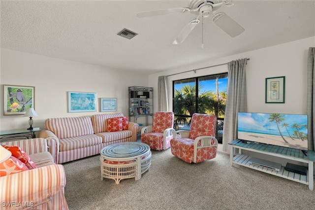 carpeted living room featuring ceiling fan and a textured ceiling