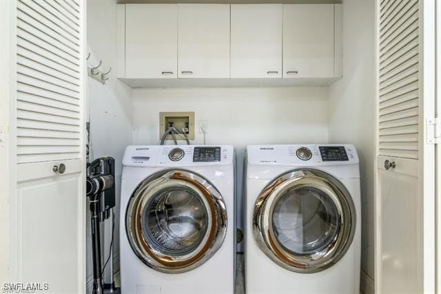 laundry area featuring separate washer and dryer and cabinets