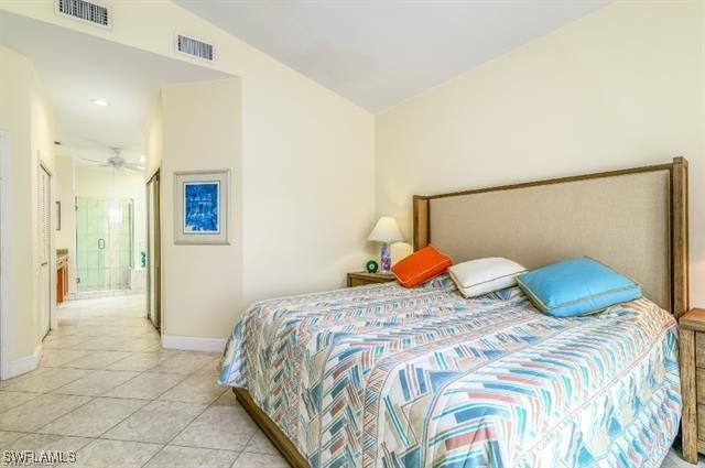 bedroom with light tile patterned floors and vaulted ceiling