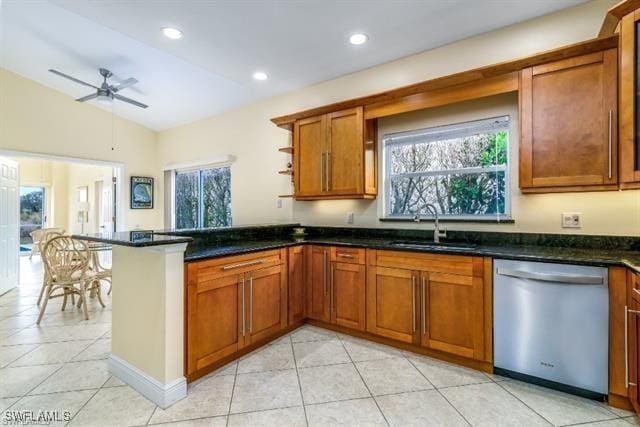 kitchen featuring vaulted ceiling, sink, dishwasher, dark stone counters, and kitchen peninsula