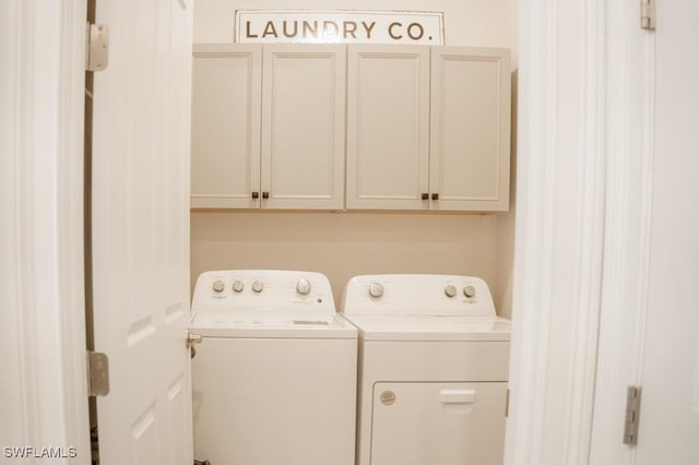 washroom featuring cabinets and washing machine and clothes dryer