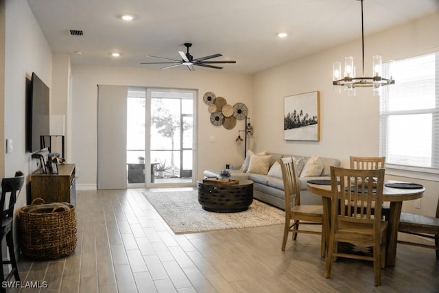 living room featuring hardwood / wood-style flooring and ceiling fan with notable chandelier