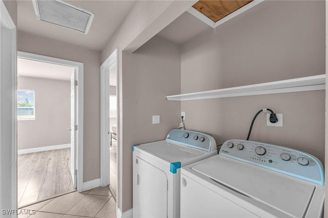 clothes washing area with separate washer and dryer and light tile patterned floors