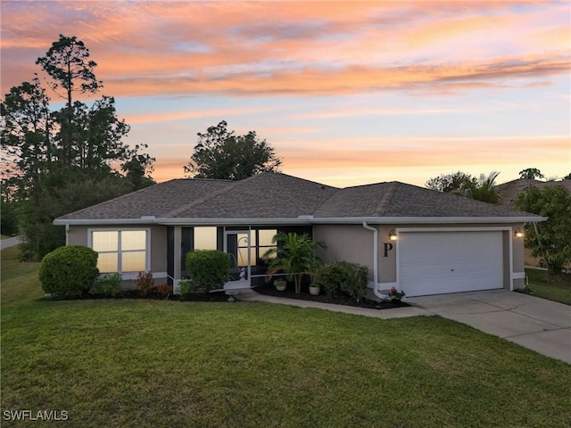 view of front of home featuring a garage and a yard