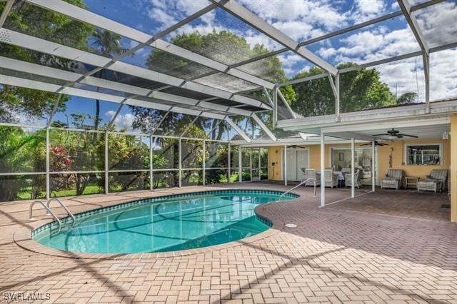 view of swimming pool featuring ceiling fan, glass enclosure, and a patio area