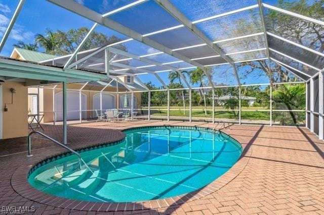 view of swimming pool with glass enclosure and a patio area