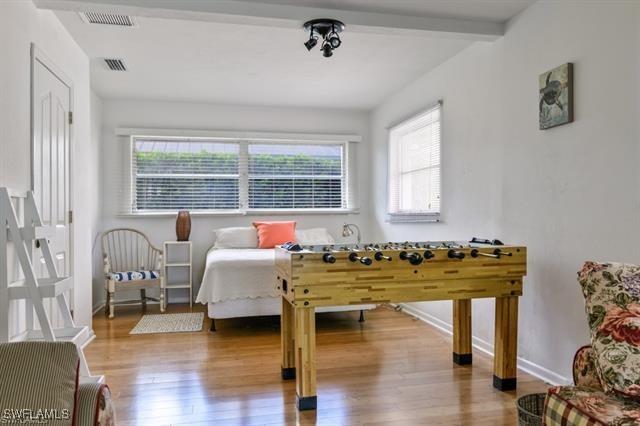 bedroom featuring beamed ceiling and hardwood / wood-style floors