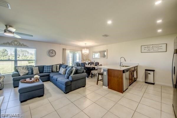 living room featuring light tile patterned flooring, ceiling fan, and sink