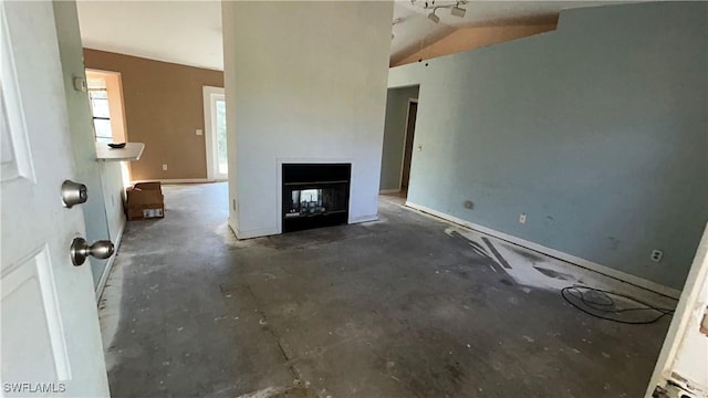 unfurnished living room with lofted ceiling and a multi sided fireplace