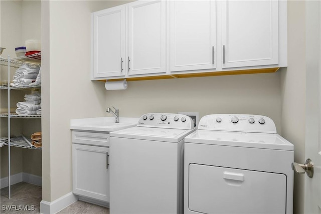 clothes washing area with cabinets, separate washer and dryer, and sink