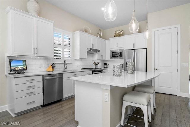 kitchen with white cabinetry, sink, a kitchen island, and appliances with stainless steel finishes