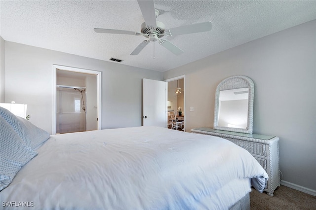 carpeted bedroom with ceiling fan and a textured ceiling