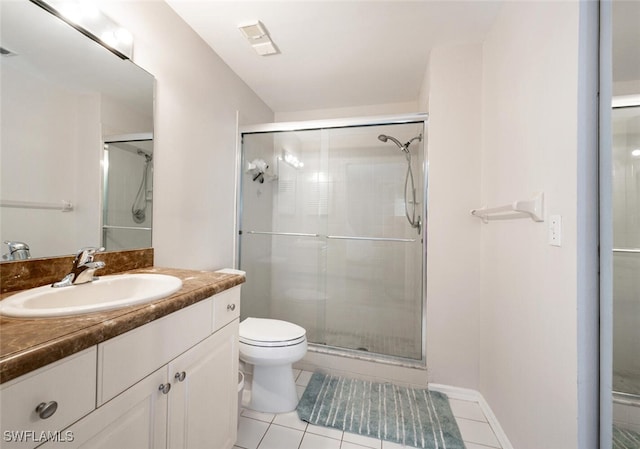 bathroom featuring tile patterned flooring, vanity, toilet, and walk in shower