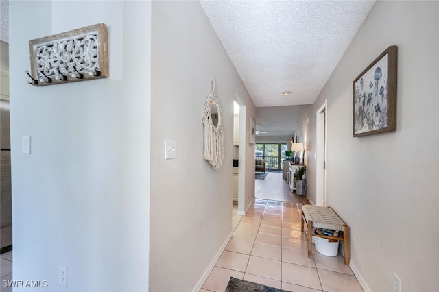 hallway featuring a textured ceiling and light tile patterned floors