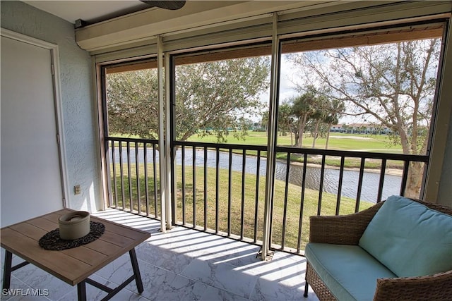 sunroom featuring a healthy amount of sunlight and a water view