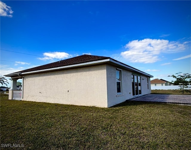 view of side of property with a yard and a patio area