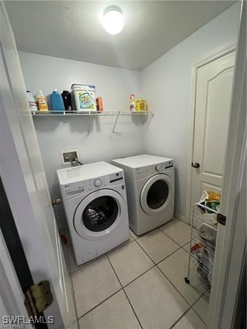 clothes washing area featuring separate washer and dryer and light tile patterned floors