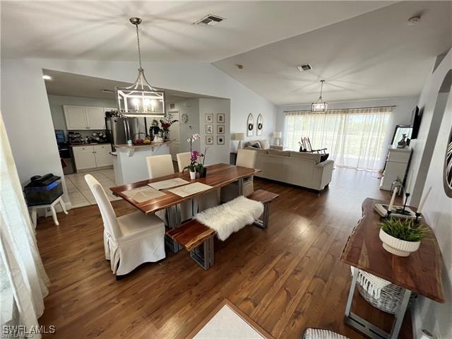 dining space with lofted ceiling and dark hardwood / wood-style flooring