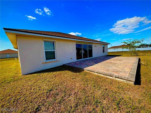 back of property featuring a yard and a patio area