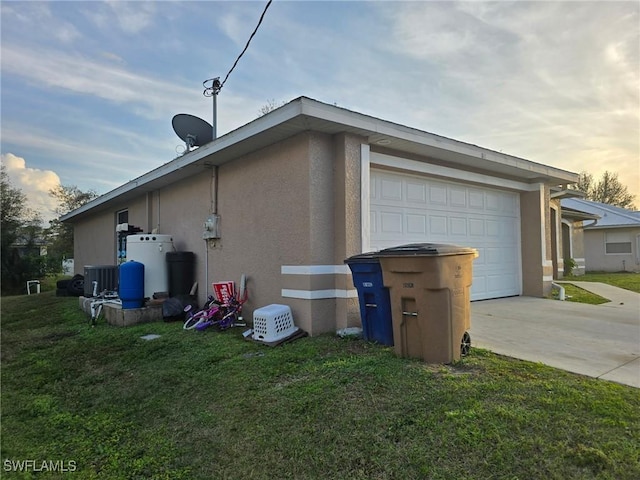 property exterior at dusk featuring a garage and a lawn