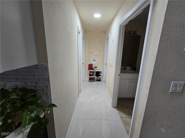 hall with sink and light tile patterned floors