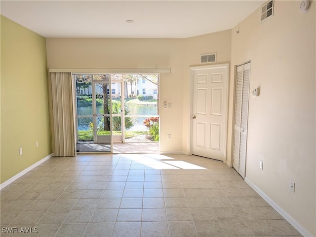 tiled empty room featuring a water view