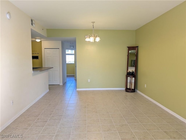 tiled empty room featuring an inviting chandelier