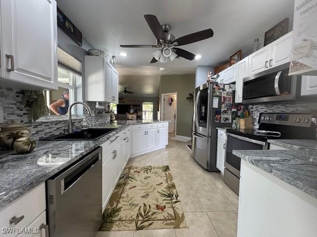 kitchen with stainless steel appliances, white cabinetry, sink, and light tile patterned floors