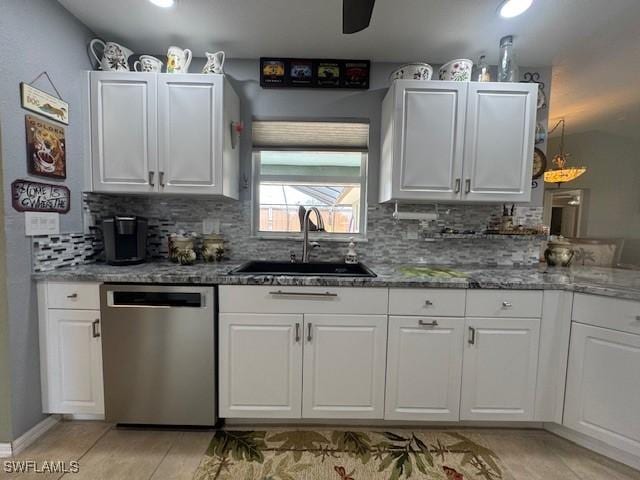 kitchen featuring white cabinetry, dishwasher, sink, dark stone countertops, and decorative backsplash