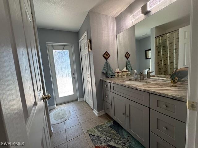 bathroom featuring vanity, tile patterned flooring, and a textured ceiling