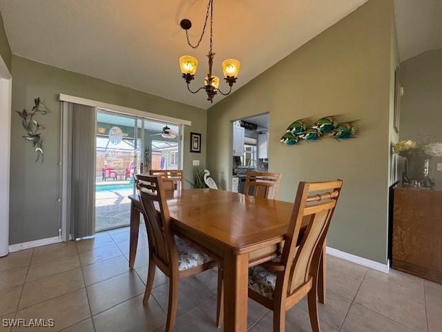 tiled dining area with vaulted ceiling and ceiling fan with notable chandelier