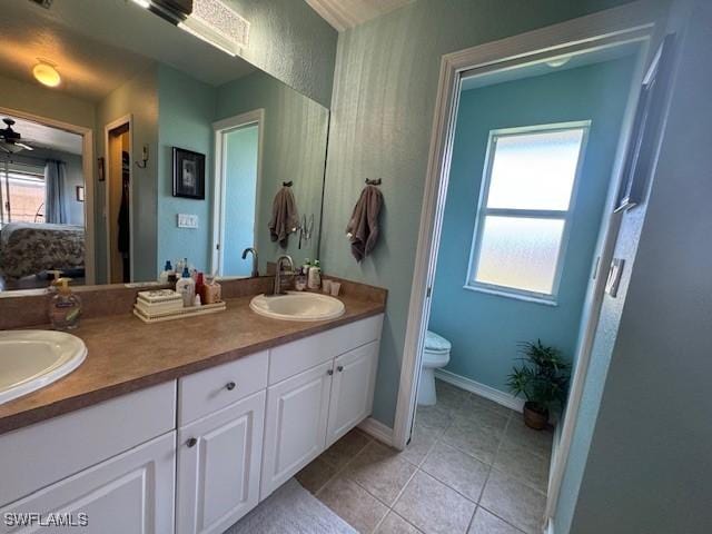 bathroom with vanity, plenty of natural light, tile patterned floors, and toilet