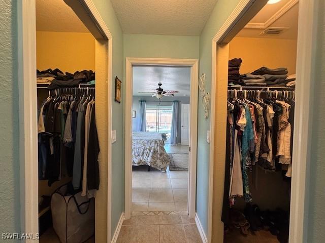 spacious closet with light tile patterned floors and ceiling fan