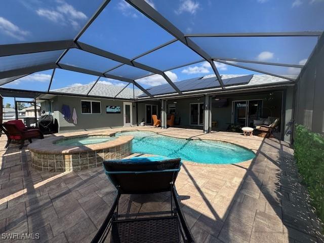 view of swimming pool with an in ground hot tub, a lanai, and a patio area