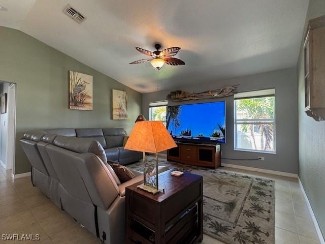 living room featuring light tile patterned flooring, ceiling fan, and vaulted ceiling