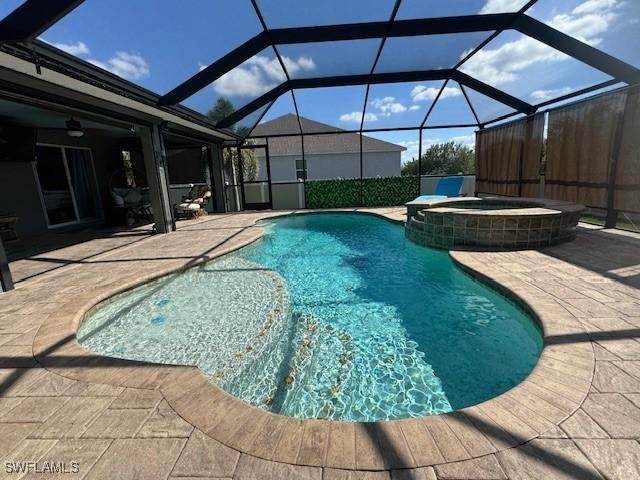 view of swimming pool featuring an in ground hot tub, a lanai, and a patio area