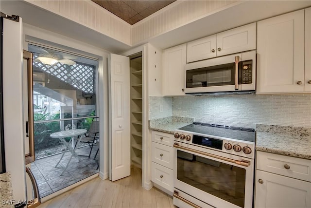 kitchen with white cabinetry, light stone counters, tasteful backsplash, and appliances with stainless steel finishes