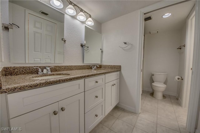 bathroom featuring vanity, tile patterned floors, and toilet