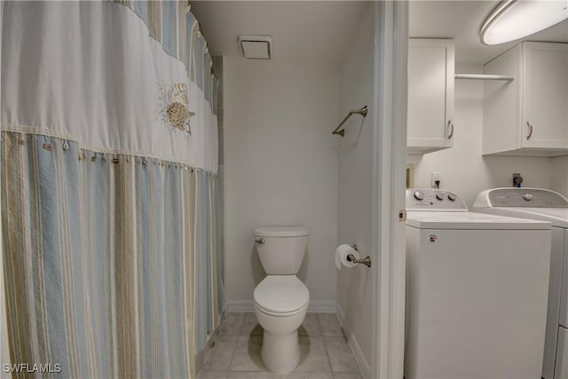 bathroom featuring washing machine and clothes dryer, tile patterned floors, and toilet