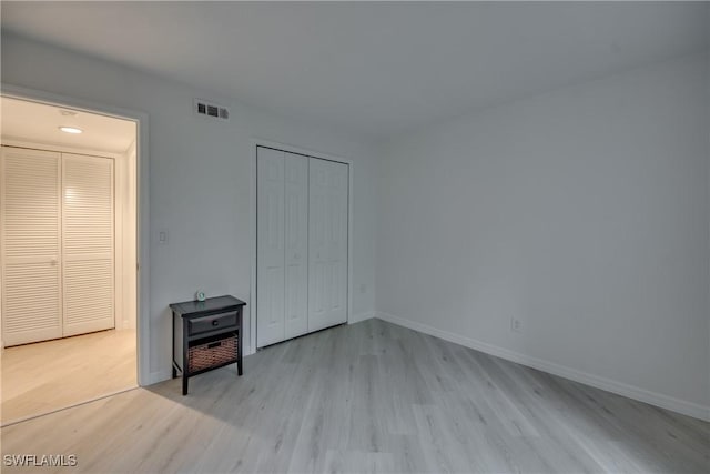 unfurnished bedroom with light wood-type flooring and a closet