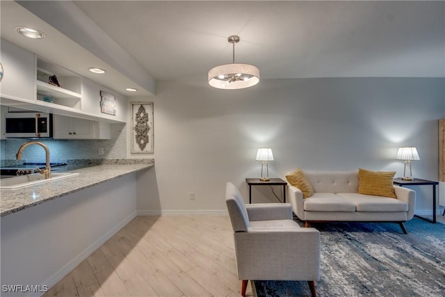 living room featuring sink and light wood-type flooring