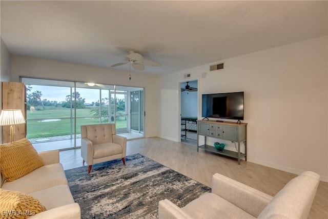 living room with ceiling fan and light hardwood / wood-style flooring