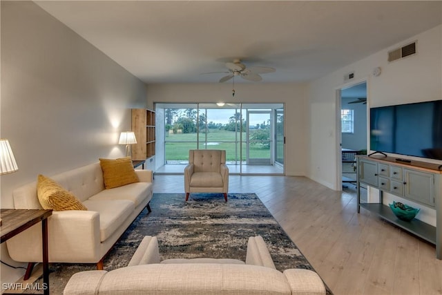 living room featuring light hardwood / wood-style flooring and ceiling fan